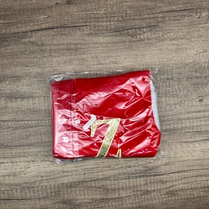 Red velvet Christmas stocking with golden glitter letter Z on a rustic wooden background