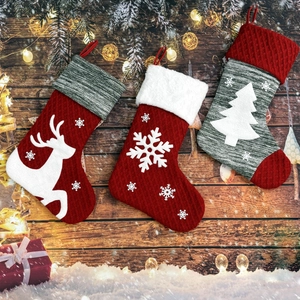 Dettaglio di tre calze di Natale in maglia con motivi di renne e fiocchi di neve
