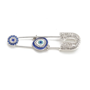 Detail of silver-tone evil eye safety pin brooch with blue crystals and lucky charms