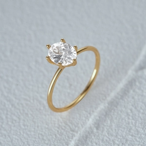 Detailed 45-degree angle of a luxury gold ring with a large oval-cut diamond and six-prong setting