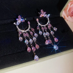 Gros plan de boucles d'oreilles cœur vintage avec zircons roses dans un écrin de velours