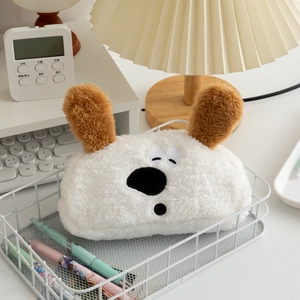 Cute white plush dog pencil case with floppy brown ears on a minimalist desk setup