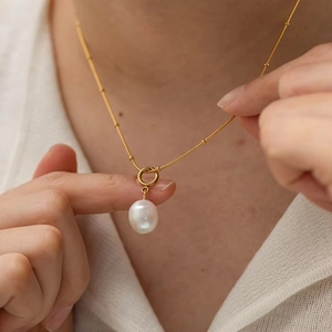 Elegant gold chain necklace featuring a large oval white freshwater pearl pendant for women