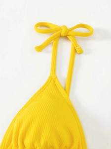 Close-up of bright yellow ribbed bikini top featuring adjustable bow tie straps and fine stitching