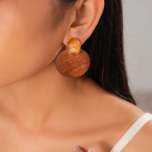 Gros plan sur des boucles d'oreilles géométriques en résine et bois de style rétro