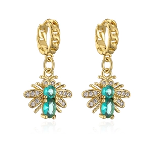 Macro shot of gold-plated bee earrings with green zircon stones and micro-pave detailing