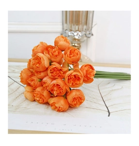 Detailed close-up of realistic orange artificial tea roses on decorative paper background