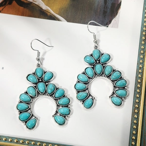 Detailed close-up of Bohemian silver earrings with turquoise resin stones and ear hooks