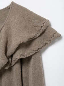Vue macro d'un pull en maille marron avec col à volants et détails en dentelle pointelle