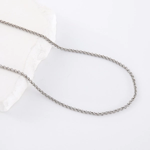 Minimalist silver stainless steel chain necklace on a white stone decorative background