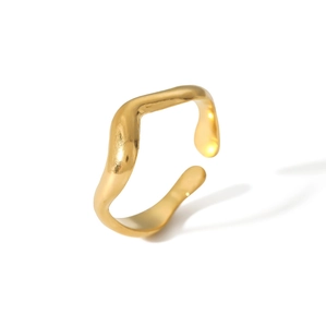 Macro detail of wave-shaped gold-plated stainless steel ring with polished wavy texture