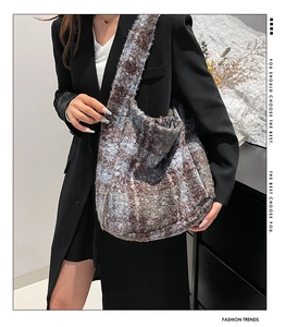 Detailed view of large plaid plush shoulder bag in blue and brown on a hobo tote