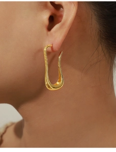 Close-up of elegant gold U-shaped curved earrings with a minimalist geometric design