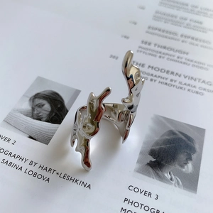 Artistic silver irregular fluid ring shown on minimalist editorial fashion magazine