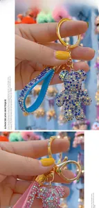 Detail of crystal rhinestones bear keychains with glittery hand straps in blue and pink