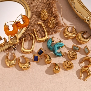 Close-up of vintage 18K gold plated hollow earrings with colorful gemstone accents
