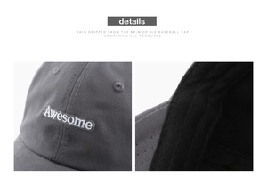 Detalle de gorra gris oscuro con bordado blanco y acabados de costuras precisas