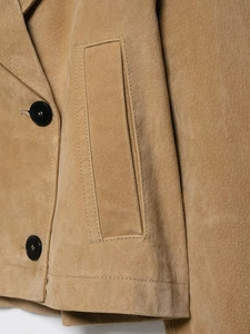 Detailed close-up of camel suede jacket featuring black buttons and stitching