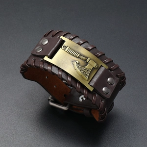 Detail of Viking axe charm on braided brown leather bracelet with metal rivets
