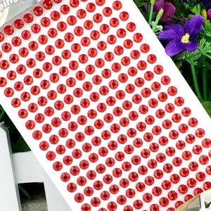 Close-up of a sheet of 3mm red round acrylic crystal stickers for DIY crafts