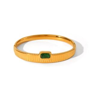Gold plated stainless steel cuff bracelet featuring vertical texture and green zircon stone