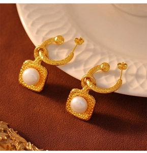 Detailed view of vintage gold hammered texture earrings with elegant freshwater pearls