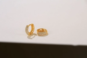 Macro shot of S925 sterling silver gold earrings with three-row pavé-set zircons