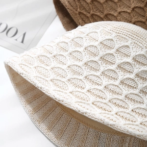 Detailed view of cream crochet bucket hat with intricate fish scale knit and inner sweatband