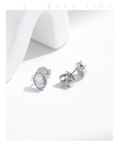 Close-up of S925 sterling silver stamp on halo-style sparkling oval stud earrings