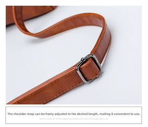 Detail of adjustable oil-wax leather shoulder strap with a gun-black metal buckle