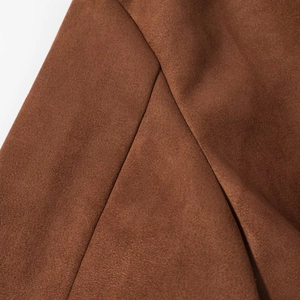 Detailed close-up of brown faux suede fabric and high-quality stitching on the jacket