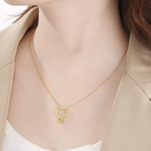 Elegant gold hollow cat pendant necklace in stainless steel worn by a model