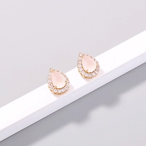 Macro detail of pear-cut pink zircon earrings with rose gold setting and white stones
