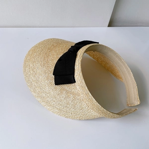 Detailed weave of beige straw sun visor with contrast black ribbon bow detail