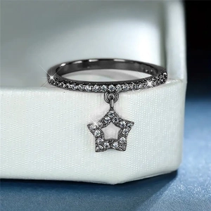 Star charm ring in gunmetal black alloy with zircon pavé on a white jewelry box display