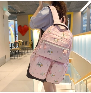 Close-up detail of pink cartoon bear backpack showing durable nylon fabric and multi-pockets