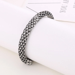 Macro detail of retro punk dragon scale texture on silver titanium steel cuff bracelet