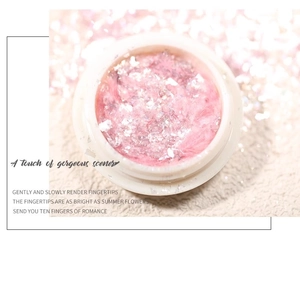 Macro shot of pink aurora opal nail glitter powder with sparkling sequins in a white jar