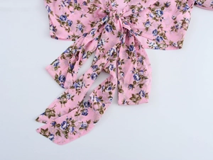 Dettaglio della camicetta floreale boho rosa con nodo frontale regolabile e tessuto morbido
