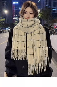 Detail of beige scarf with black windowpane check pattern and soft fringe edges