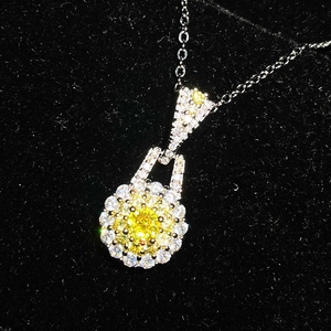 Detailed macro view of a round yellow gemstone pendant with sparkling zircon accents