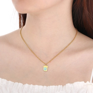 Détail d'un collier pendentif tasse à café doré avec un cœur en émail bleu élégant