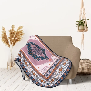 Close-up of bohemian geometric patterned flannel throw blanket draped over a brown sofa