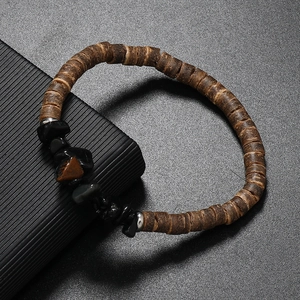 Close-up of bohemian beaded bracelet featuring dark wood beads and natural tiger eye stone
