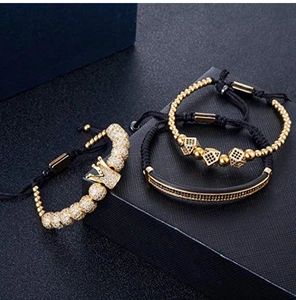 Detail of 3pcs gold and black bracelet set with crown and cubic zirconia charms