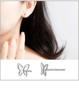 Close-up of S999 sterling silver butterfly stud earrings with engraved hallmark detail