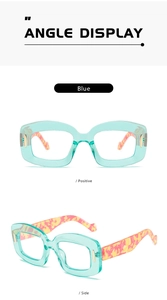 Detail view of light blue transparent acetate frames with orange patterned temples and gold accents
