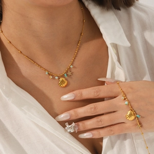 Golden shell necklace and bracelet set with turquoise beads and star charms on model