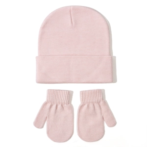 Close-up of pink knitted baby beanie and matching mittens set for winter warmth
