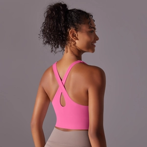 Détail de la brassière de sport rose vif avec dos croisé et tissu à haute élasticité